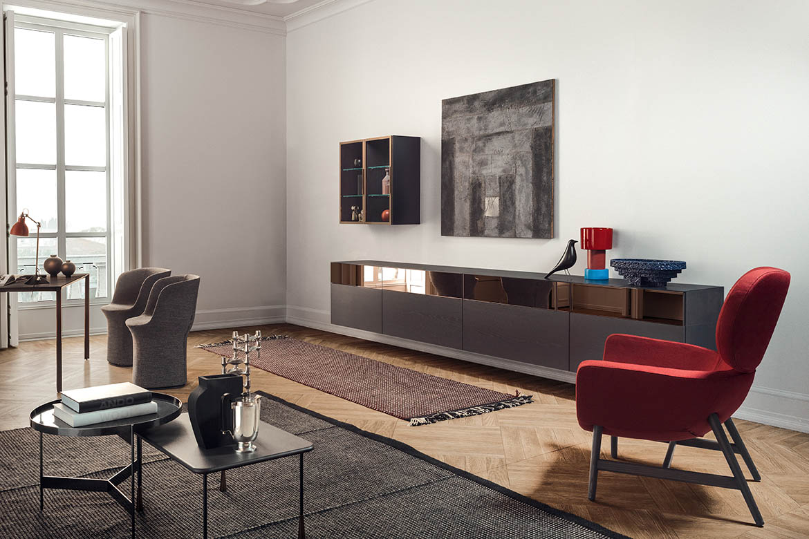 credenza sospesa con frontali in specchio bronzo e legno rovere grigio, vetrina venere fissata alla parete poltrona rossa laurie design Calvi Brambilla