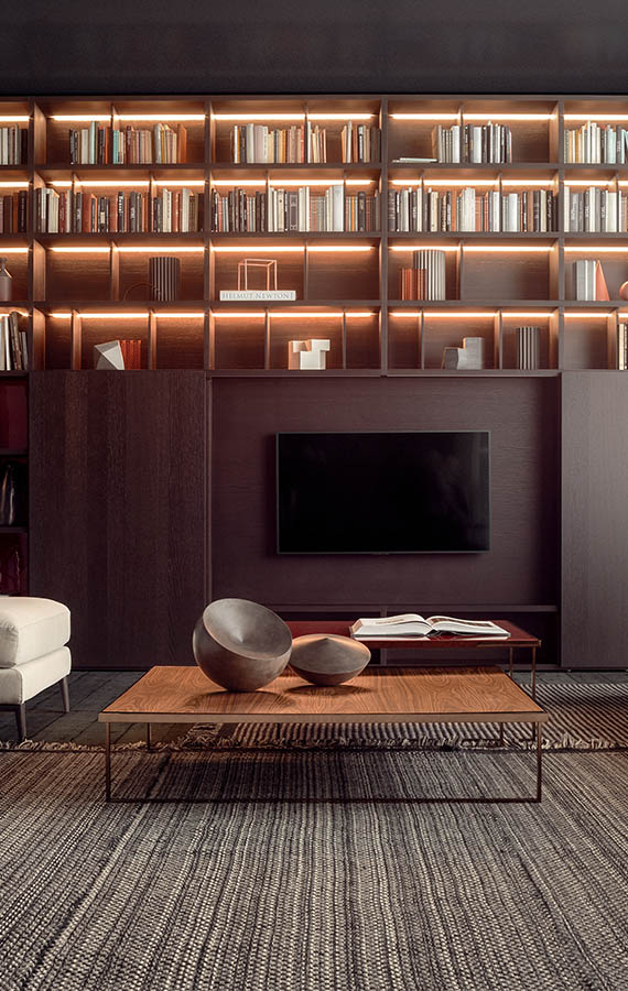 libreria con luci e con porte scorrevoli in legno che nascondono il televisore, tavolini icaro con struttura in metallo e piano in legno pianca