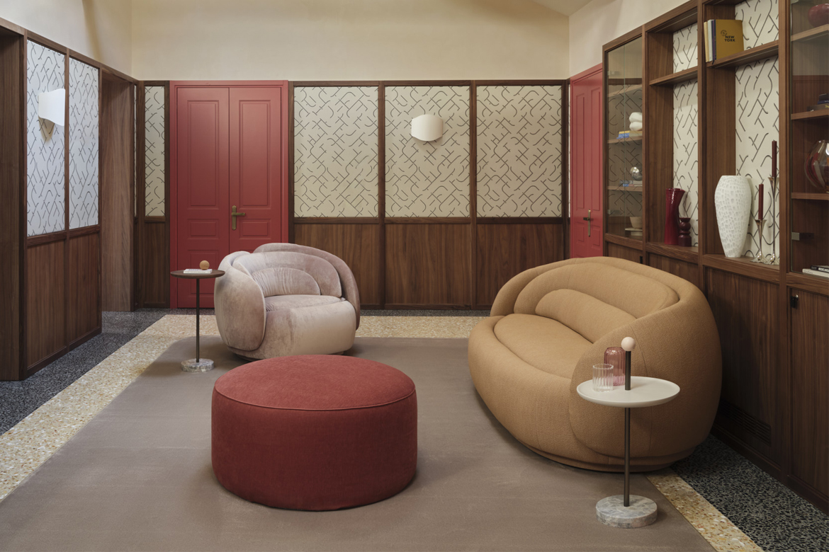 Zona living di Elizabeth Unique Venice arredata con divano e poltrona peonia di Cristina Celestino per Pianca e pouf Eden rosso